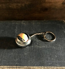 Load image into Gallery viewer, blinking doll eye keychain shown laid down, eye is closed 