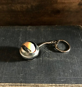 blinking doll eye keychain shown laid down, eye is closed 