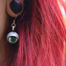 Load image into Gallery viewer, close up of blinking doll eye earring being worn by model with red hair and stretched ear lobes