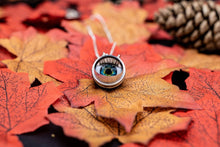 Load image into Gallery viewer, Eyeball partially open showing the blue and green colour and long lashes, sat on autumnal leaves