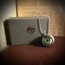 Load image into Gallery viewer, green doll eye necklace shown with jewellery box - box is grey with silver foil eye logo
