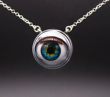 Load image into Gallery viewer, Blinking doll eye necklace with bright green and blue iris on sterling silver chain with grey beckground