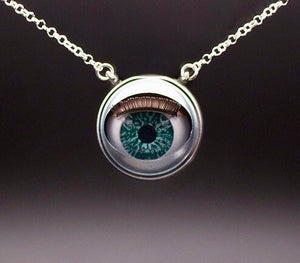 Aqua doll eye necklace on plain background