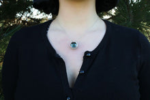 Load image into Gallery viewer, Modeal wears black cardigan showing eyeball necklace resting on chest 