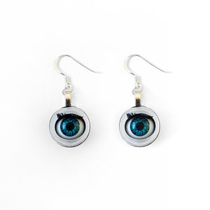 Blinking doll eye earrings shown on plain white background, earrings are made with vintage style doll eyes with blue irises. 