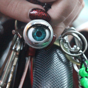 blinking doll eye keychain shown on steering wheel