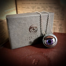 Load image into Gallery viewer, Purple doll eye necklace shown with grey packaging and silver foil design