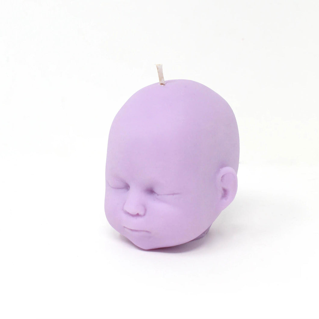 lilac/light purple doll head shaped candle on white background