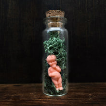 Load image into Gallery viewer, minature glass vial with cork lid, enclosing a very small plastic doll figurine with moss. Doll has a vintage style appearance and is all pink/peach in colour