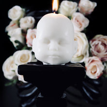 Load image into Gallery viewer, White doll head candle on black pilar with white rosese in the background, dark gothic image