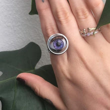 Load image into Gallery viewer, close up of doll eye ring shown on hand with other rings and foliage in background