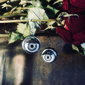 lARGE grey Doll eye earrings hung on dried roses