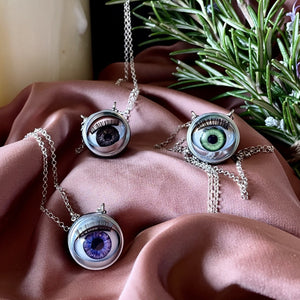 eye necklaces sat on pink fabric 