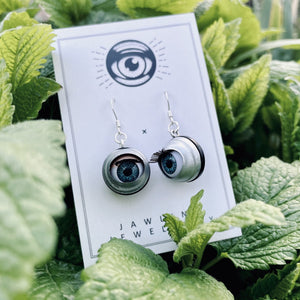 vintage style blue doll eye earrings shown on herbs